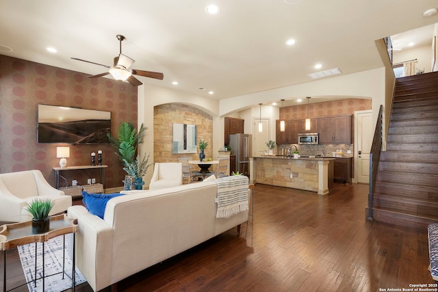 living room featuring ceiling fan, dark hardwood / wood-style flooring, and sink