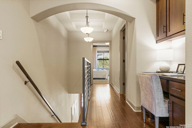 corridor featuring dark hardwood / wood-style floors and a tray ceiling