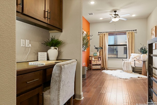 office area featuring ceiling fan, dark hardwood / wood-style flooring, and built in desk