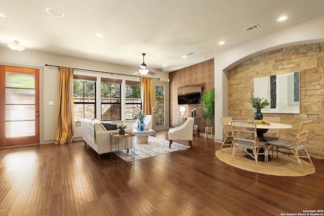 living room featuring ceiling fan and dark hardwood / wood-style flooring