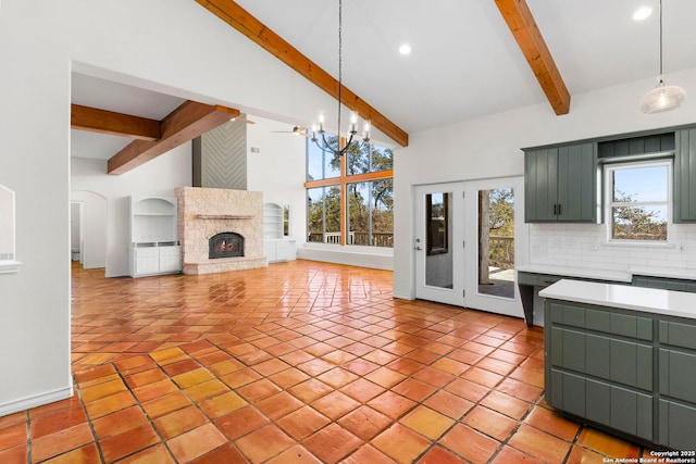 kitchen featuring high vaulted ceiling, hanging light fixtures, a notable chandelier, beam ceiling, and backsplash