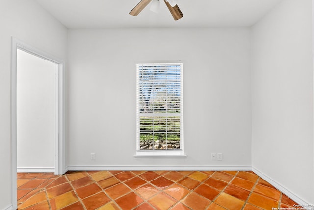 empty room with ceiling fan and tile patterned flooring