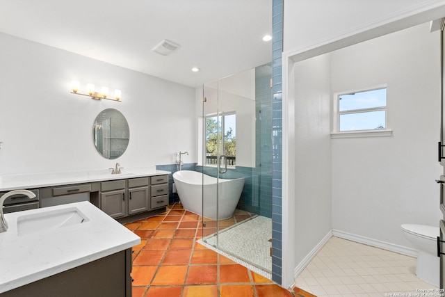 bathroom with a bathing tub, tile walls, tile patterned flooring, vanity, and toilet