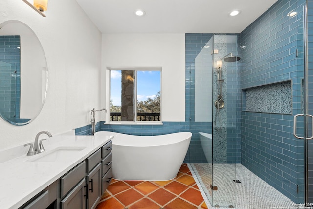 bathroom with tile patterned flooring, vanity, shower with separate bathtub, and tile walls