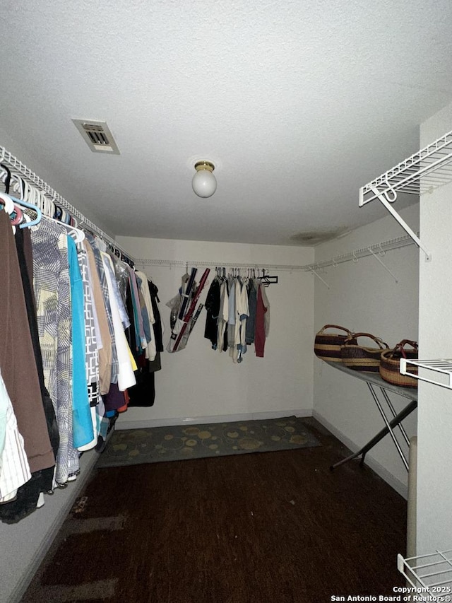 spacious closet featuring dark hardwood / wood-style flooring