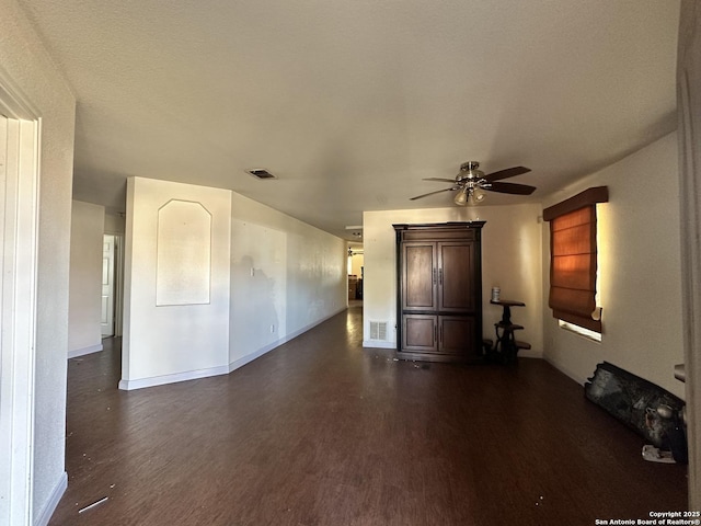 interior space featuring dark wood-type flooring and ceiling fan