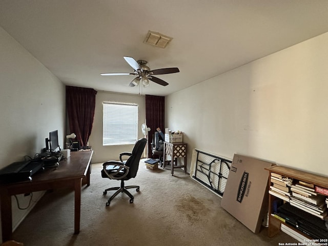 carpeted office space featuring ceiling fan