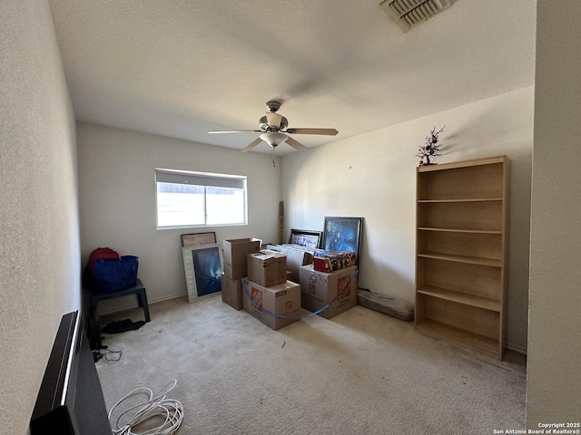 interior space featuring light carpet and ceiling fan