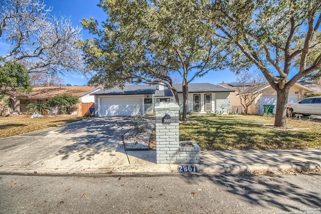 ranch-style house with a garage and a front yard