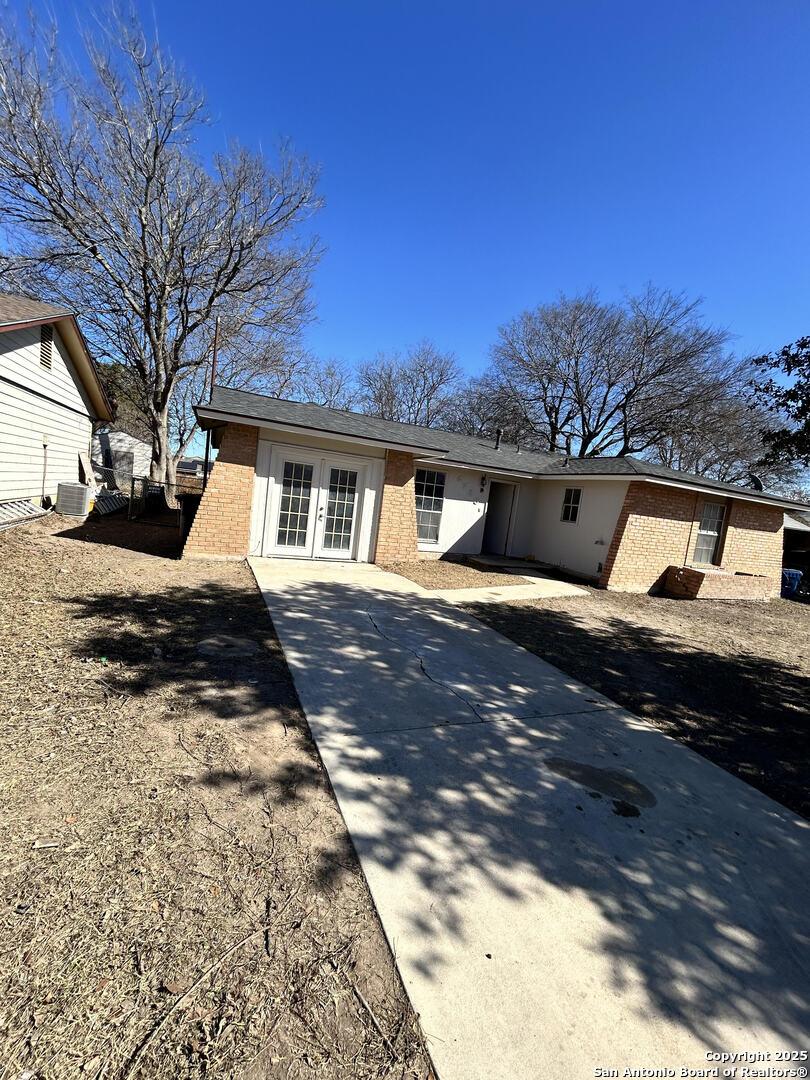 view of front of home with french doors and central AC