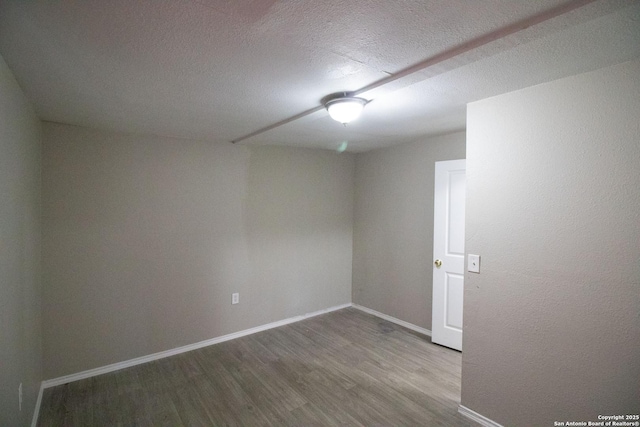 spare room with wood-type flooring and a textured ceiling