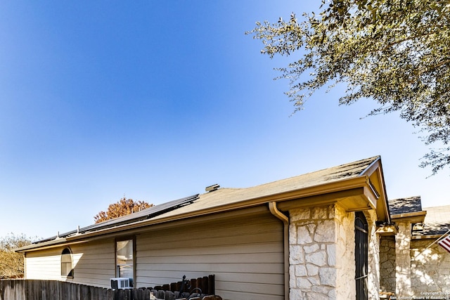 view of side of home featuring solar panels