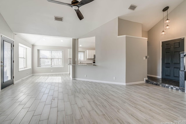 unfurnished living room with ceiling fan and vaulted ceiling