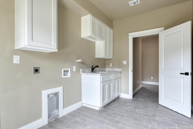 washroom with sink, cabinets, washer hookup, electric dryer hookup, and light hardwood / wood-style flooring