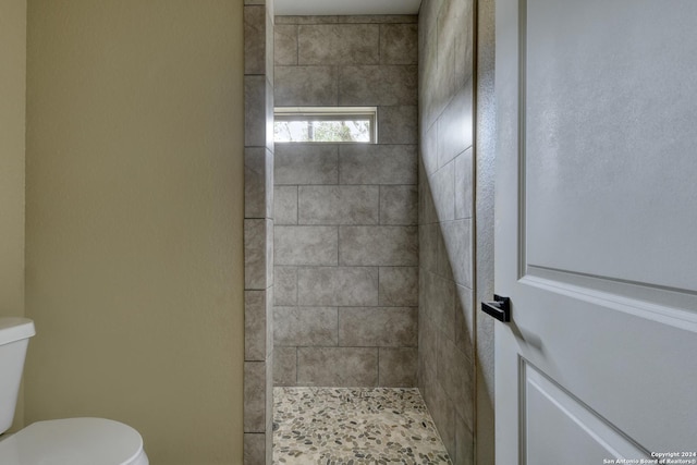 bathroom with toilet and tiled shower