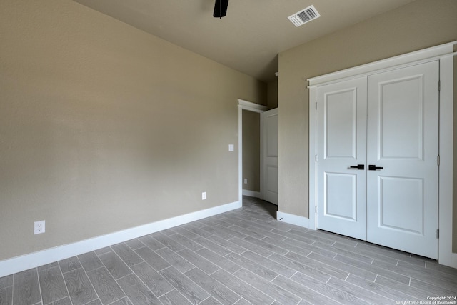 unfurnished bedroom with ceiling fan, light hardwood / wood-style floors, and a closet