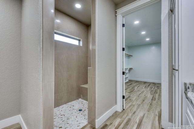 bathroom featuring hardwood / wood-style flooring and tiled shower