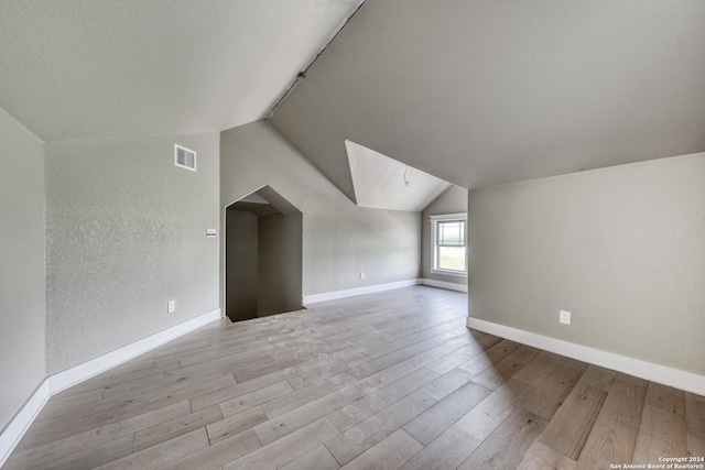 bonus room featuring light hardwood / wood-style floors and vaulted ceiling