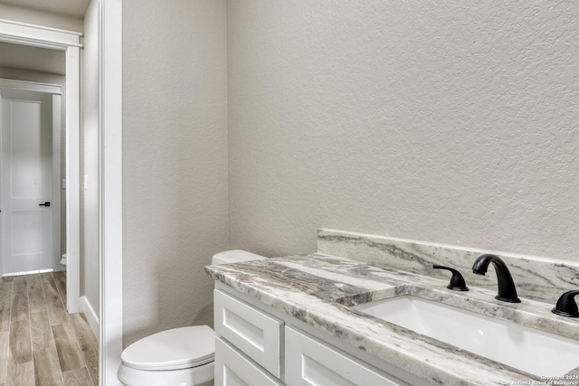 bathroom featuring hardwood / wood-style flooring, vanity, and toilet