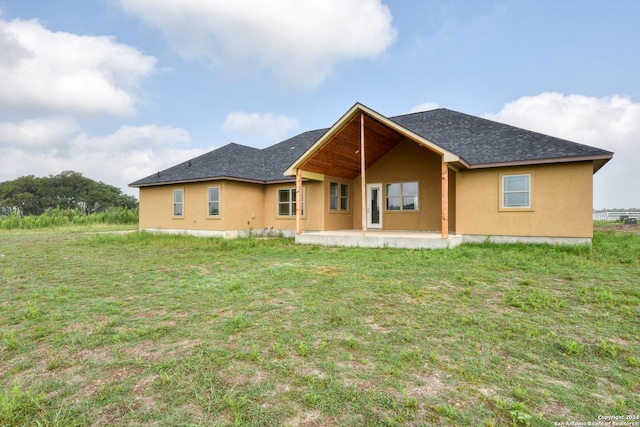 back of property featuring a patio area and a lawn