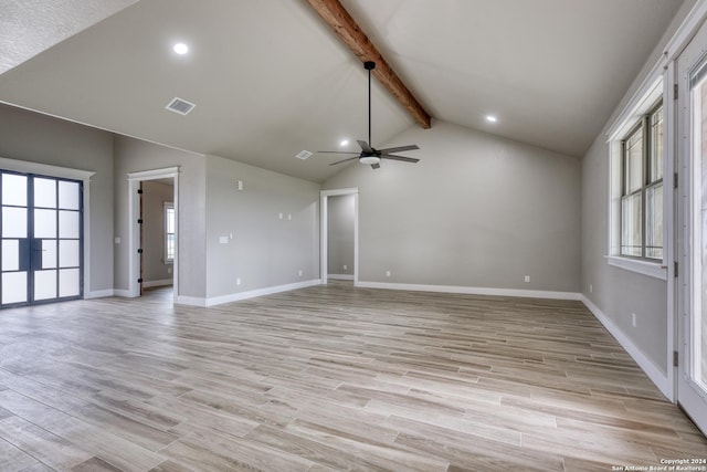 unfurnished living room with ceiling fan, lofted ceiling with beams, and light wood-type flooring