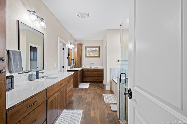 bathroom with hardwood / wood-style flooring, vanity, and separate shower and tub