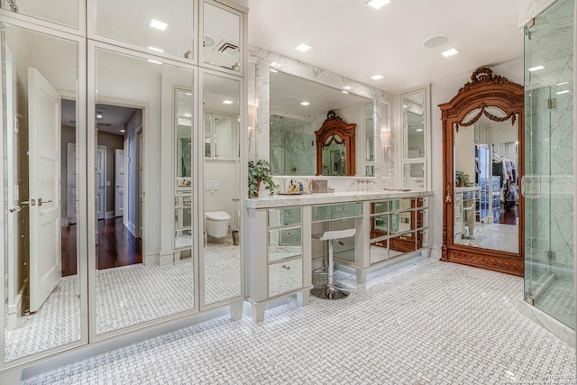 bathroom with tile patterned flooring, a shower with shower door, and toilet