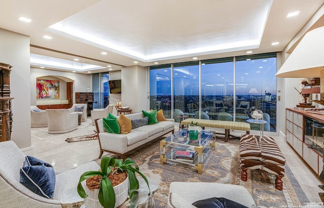 living room featuring a wall of windows and a raised ceiling