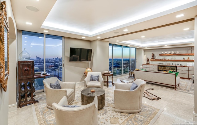 living room featuring expansive windows and a raised ceiling