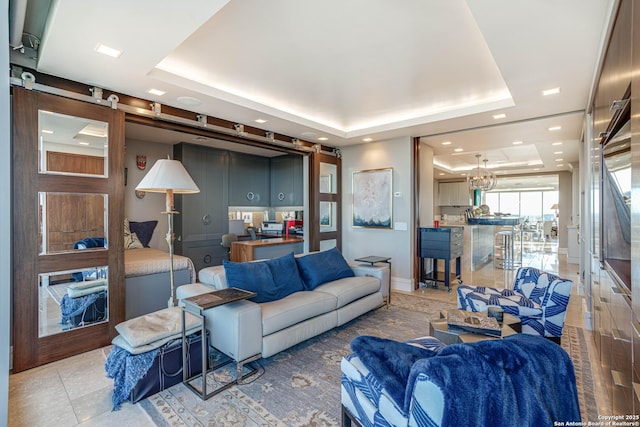 living room featuring tile patterned floors, a raised ceiling, and a barn door