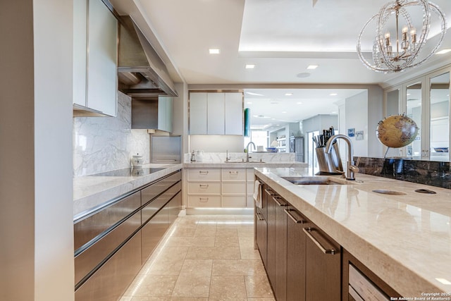 kitchen with white cabinetry, sink, black electric stovetop, and a tray ceiling