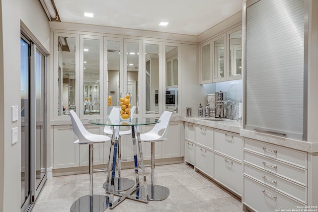 interior space featuring white cabinetry, sink, and oven