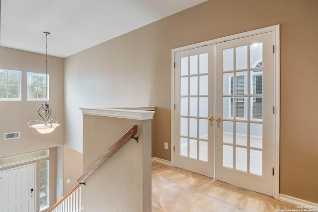 doorway with french doors and light carpet