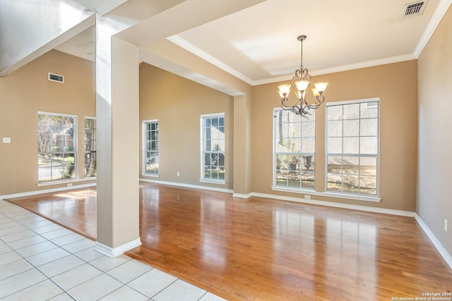 unfurnished dining area with light tile patterned floors, crown molding, and a chandelier