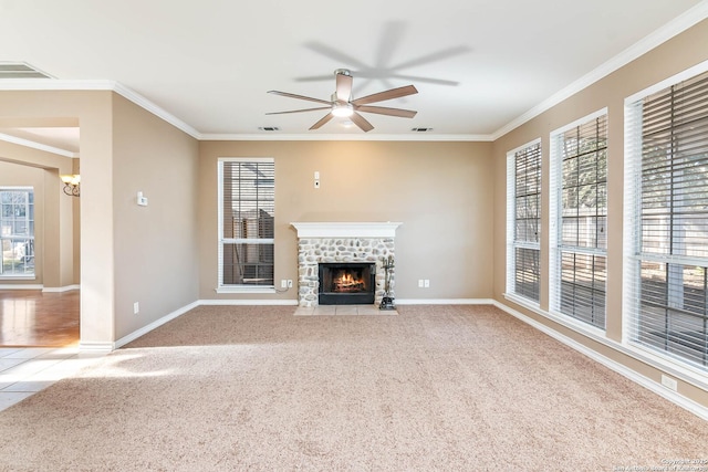 unfurnished living room with crown molding, light carpet, ceiling fan, and a fireplace