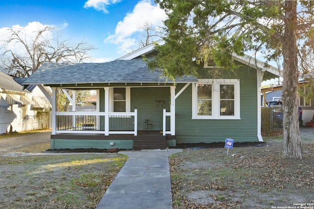 bungalow-style house with a shingled roof and covered porch