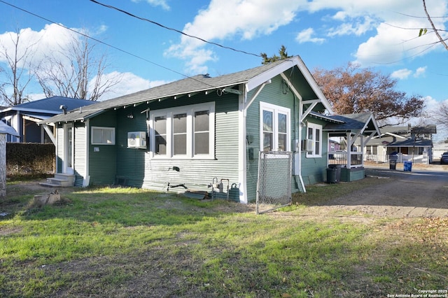 view of side of home featuring entry steps and a lawn