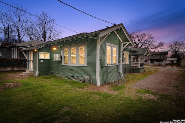 view of side of home with entry steps and a yard