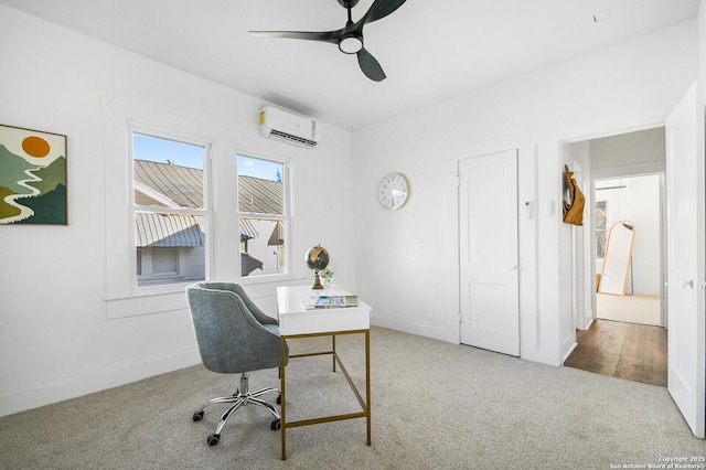 carpeted home office featuring baseboards, a ceiling fan, and a wall mounted air conditioner