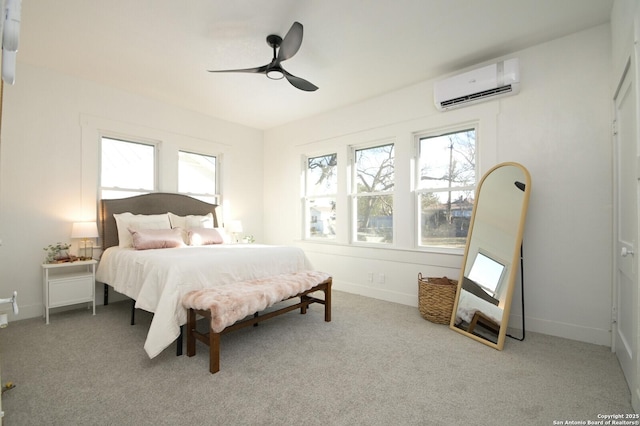 bedroom featuring light carpet, a wall unit AC, a ceiling fan, and baseboards