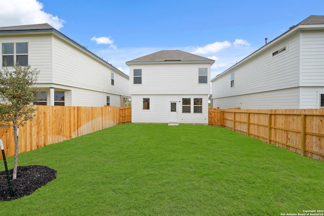 rear view of property featuring a yard