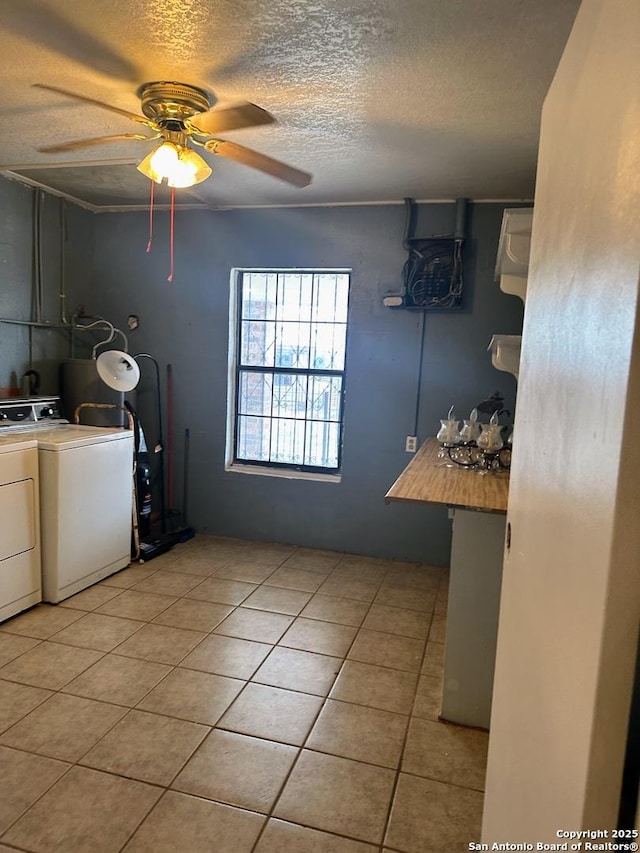 laundry area featuring ceiling fan, a textured ceiling, washing machine and clothes dryer, and light tile patterned flooring