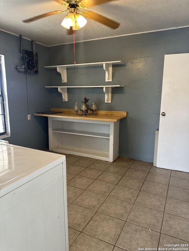 kitchen with ceiling fan, washer / clothes dryer, a textured ceiling, and light tile patterned floors