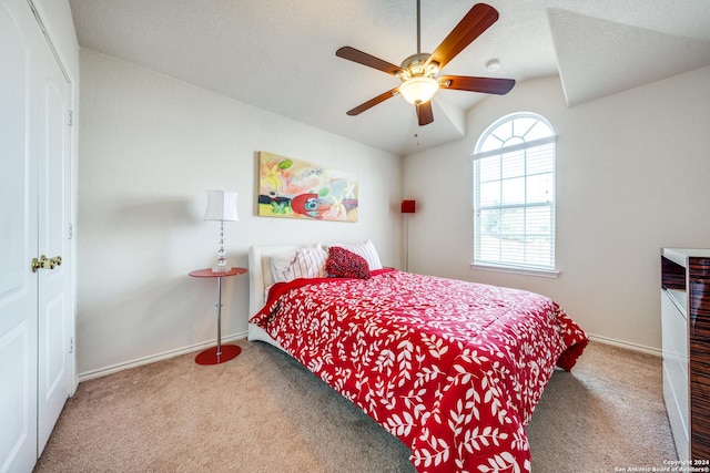 carpeted bedroom featuring lofted ceiling and ceiling fan