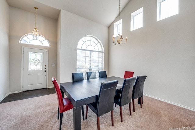 dining space featuring a high ceiling, a chandelier, and carpet