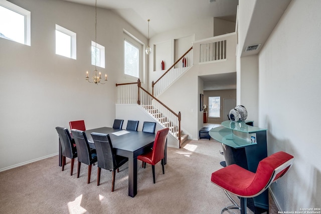 carpeted dining space featuring a notable chandelier and high vaulted ceiling