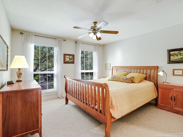 bedroom with ceiling fan and light colored carpet