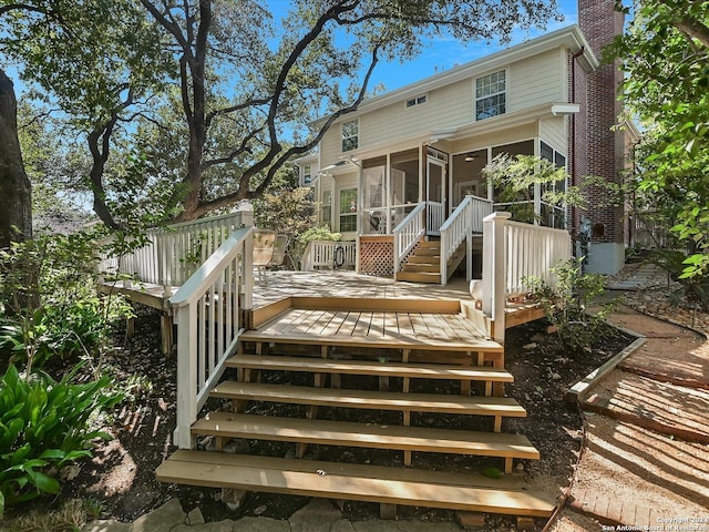 back of house featuring a sunroom and a deck