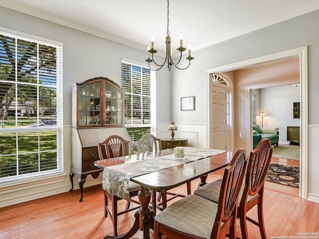 dining room with a notable chandelier, ornamental molding, and light hardwood / wood-style floors