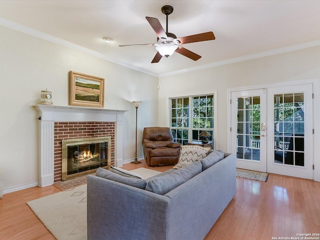 living room with light hardwood / wood-style flooring, crown molding, a wealth of natural light, and french doors